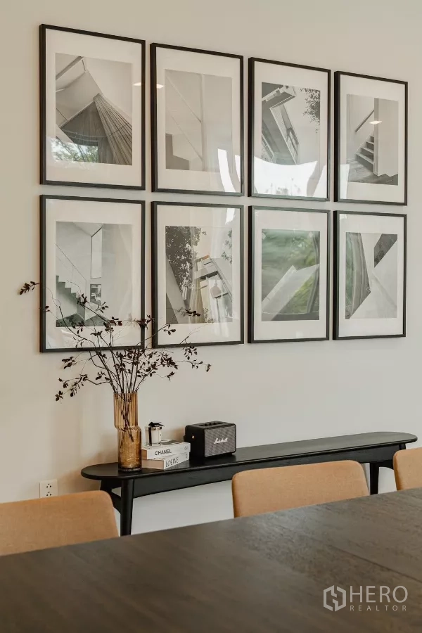 Detached House for rent in Saphan Sung, Bangkok - Gallery wall of framed black-and-white art in the dining area.