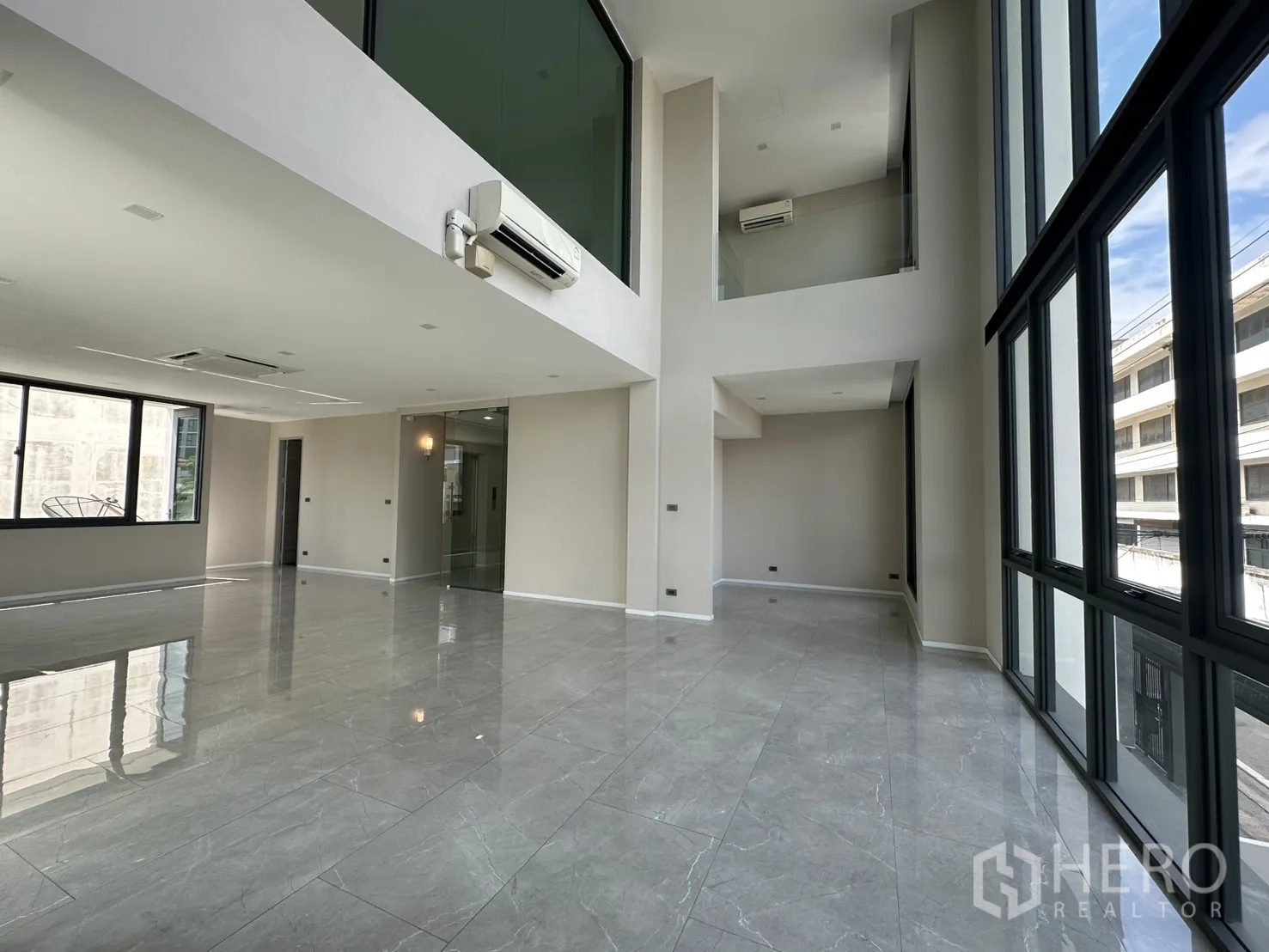 家庭办公室 for rent or sale in Suan Luang, Bangkok - 挑高双层办公空间，玻璃隔断与空调设备。