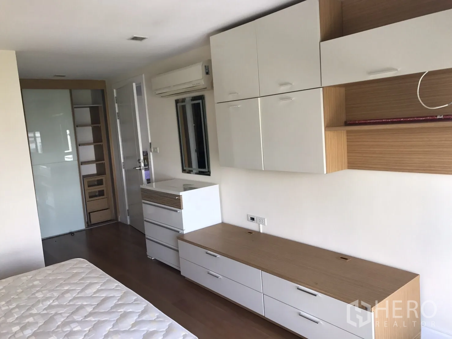 公寓 出租或出售在Watthana, Bangkok - 卧室内设白色内置柜、木质层架与推拉衣柜。