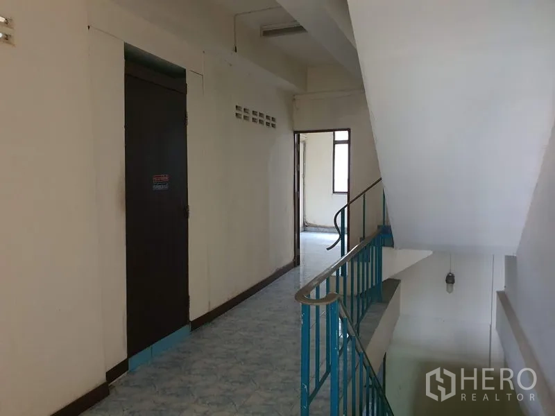 店屋 出租在Bang Rak, Bangkok - 走廊与楼梯平台，金属扶手，通往多间房门。