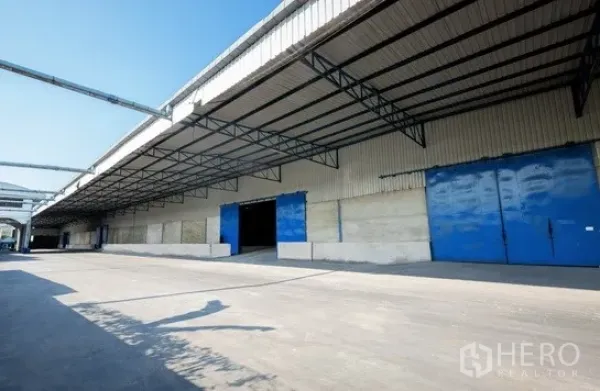 货栈 出租在Pathum Thani - 仓库长立面配多处装卸口及宽阔卡车通道。