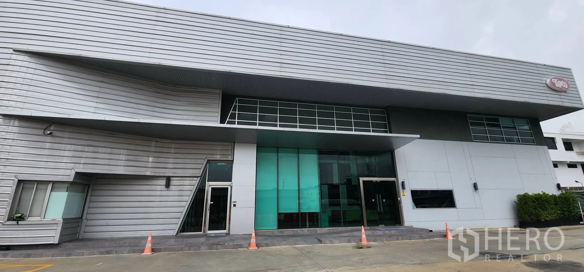 โกดัง for rent in Bang Sue, Bangkok - ด้านหน้าอาคารคลังสินค้าพร้อมประตูกระจกและชายคาทางเข้าและลานขนถ่ายด้านหน้า