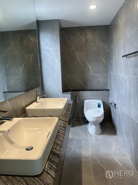 家庭办公室 for rent or sale in Suan Luang, Bangkok - 卫浴设双台盆、大镜面与仿石瓷砖。