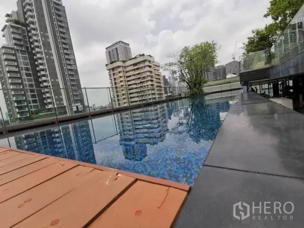 公寓 出租在Watthana, Bangkok - 屋顶无边泳池，玻璃栏杆与城市景观。