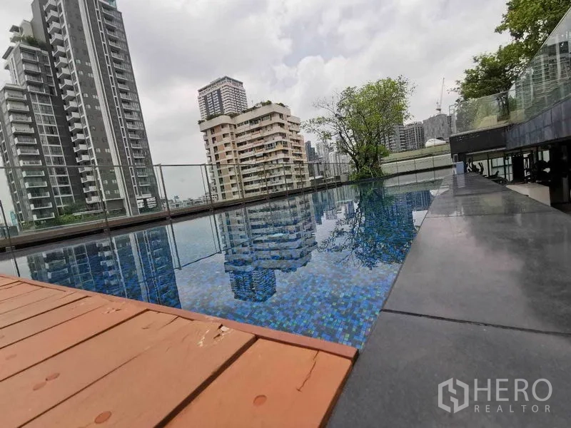 公寓 出租在Watthana, Bangkok - 屋顶无边泳池，玻璃栏杆与城市景观。