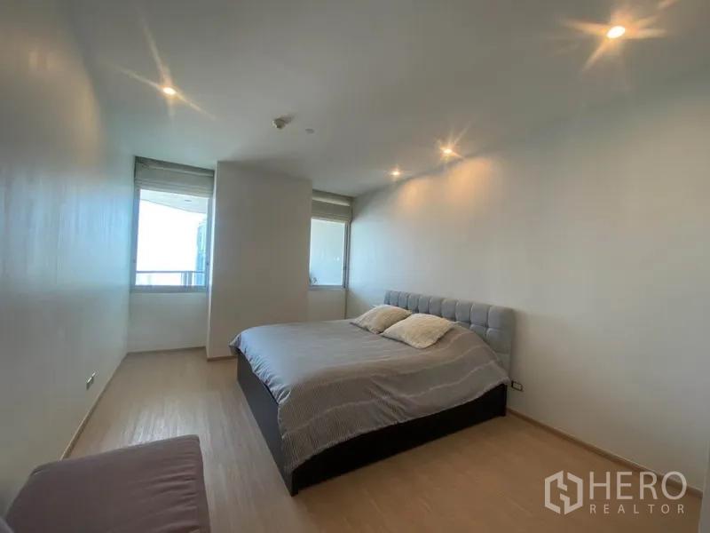 Condominium for rent in Sathon, Bangkok - Primary bedroom with king bed, recessed lighting, and window views.