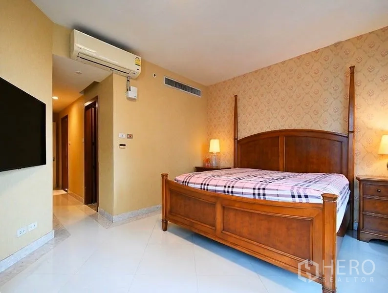 คอนโด ให้เช่าในPathum Wan, Bangkok - ห้องนอนมาสเตอร์กว้าง เตียงไม้ ผนังวอลเปเปอร์โทนอุ่น โคมไฟหัวเตียง
