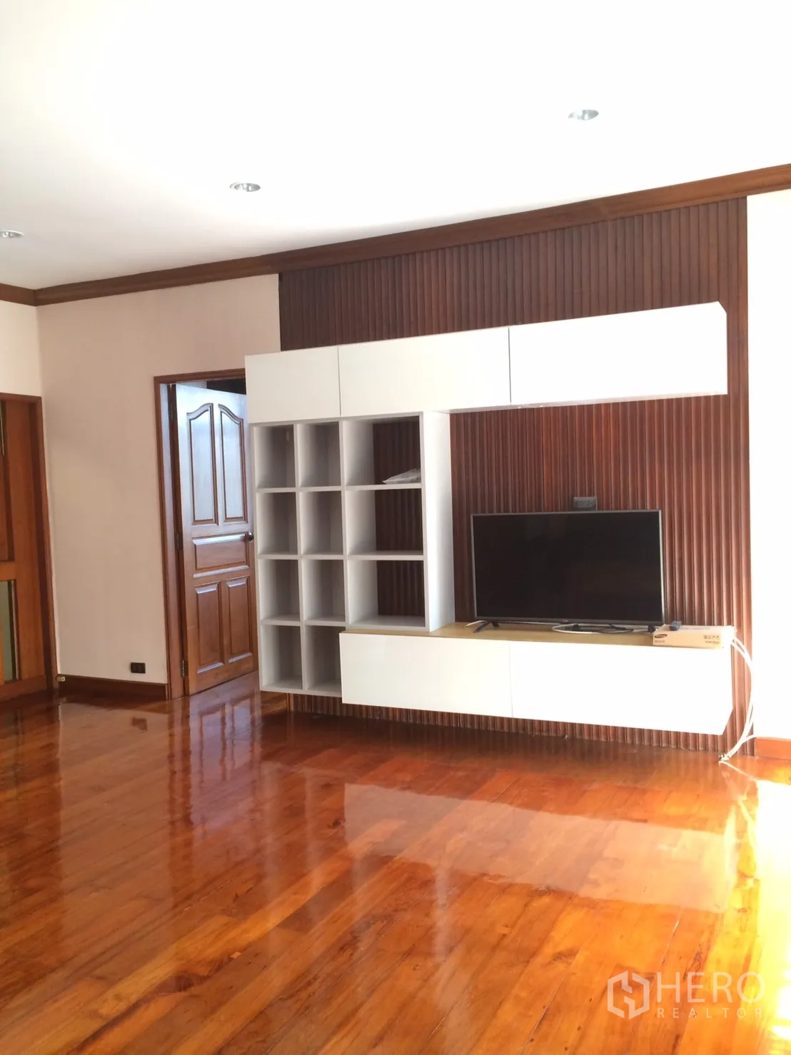 独立式住宅 出租在Khlong Toei, Bangkok - 起居室带内嵌电视与收纳，木地板光亮。