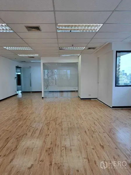 Office Space for rent in Bang Rak, Bangkok - Spacious office interior featuring a glass-partition meeting room, recessed lighting and laminate flooring.