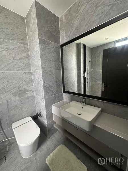 Detached House for rent in Saphan Sung, Bangkok - Contemporary bathroom with wide mirror, vanity and toilet.