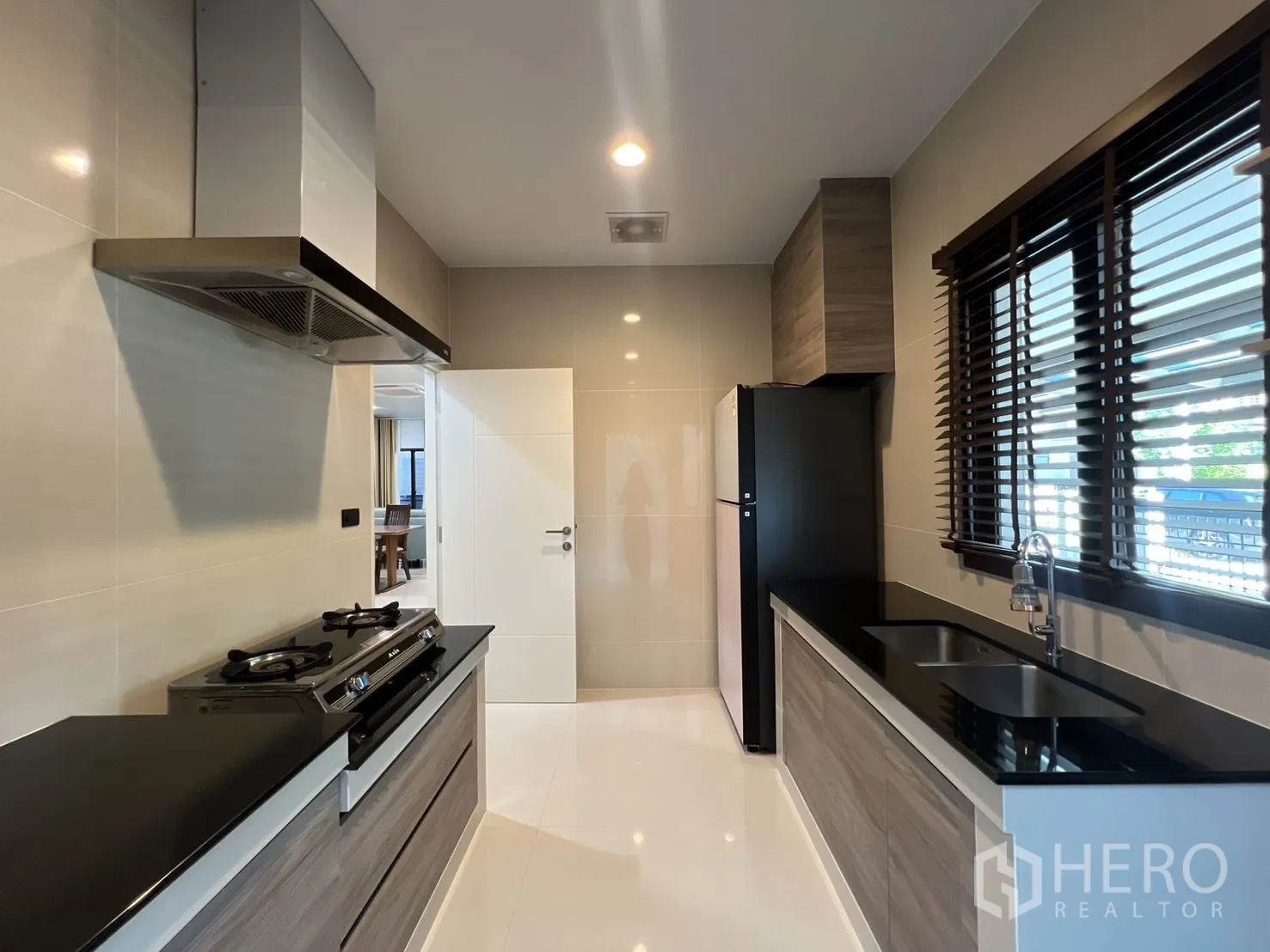 Detached House for rent or sale in Bang Kapi, Bangkok - Kitchen with dual countertops, stove, hood and refrigerator