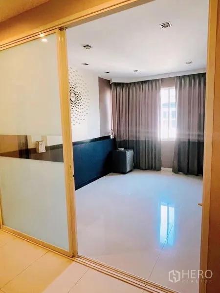 独立式住宅 出租或出售在Prawet, Bangkok - 带推拉玻璃隔断的多功能房，瓷砖地面与全高窗帘。