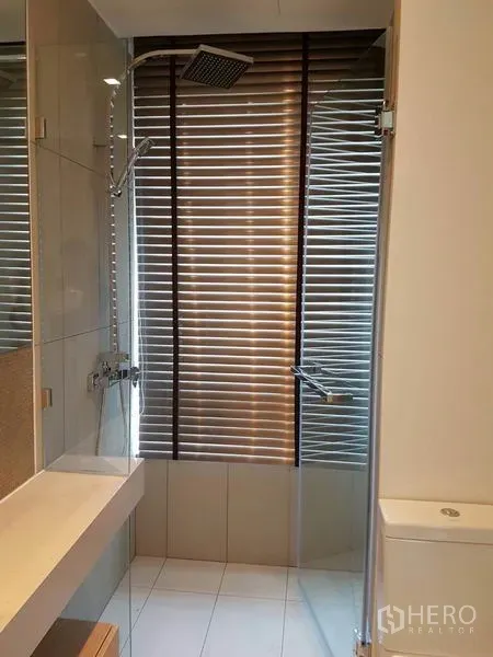 公寓 出租在Watthana, Bangkok - 浴室设玻璃淋浴间与顶喷花洒，百叶窗。