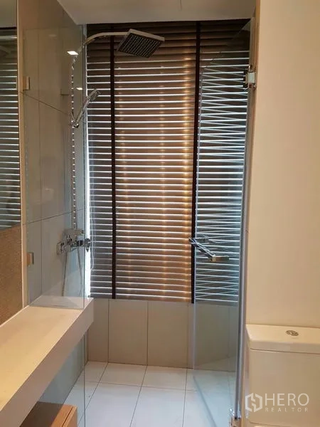 公寓 出租在Watthana, Bangkok - 浴室设玻璃淋浴间与顶喷花洒，百叶窗。