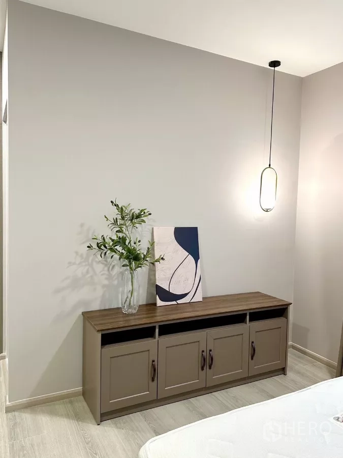 Detached House for rent in Bang Phli, Samut Prakan - Bedroom corner with sideboard, pendant light, and decorative artwork.
