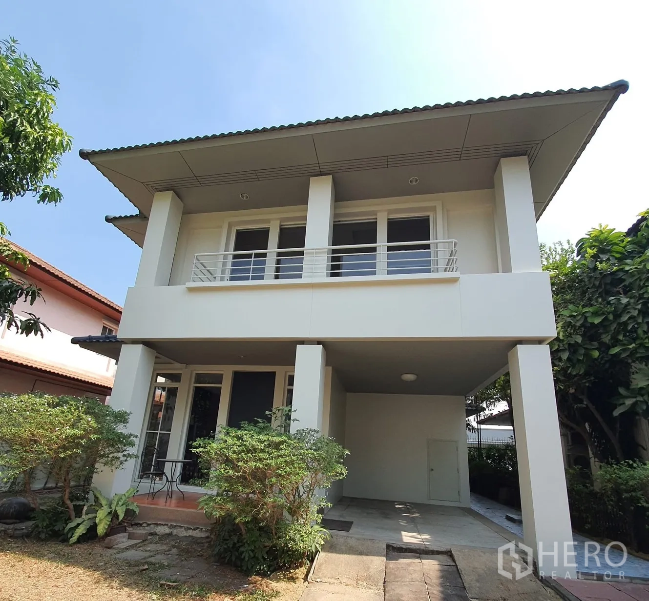 บ้านเดี่ยว for rent in Wang Thonglang, Bangkok - ด้านหน้าบ้านเดี่ยวสองชั้นพร้อมระเบียง โรงจอดรถในร่ม และสวนพุ่มไม้
