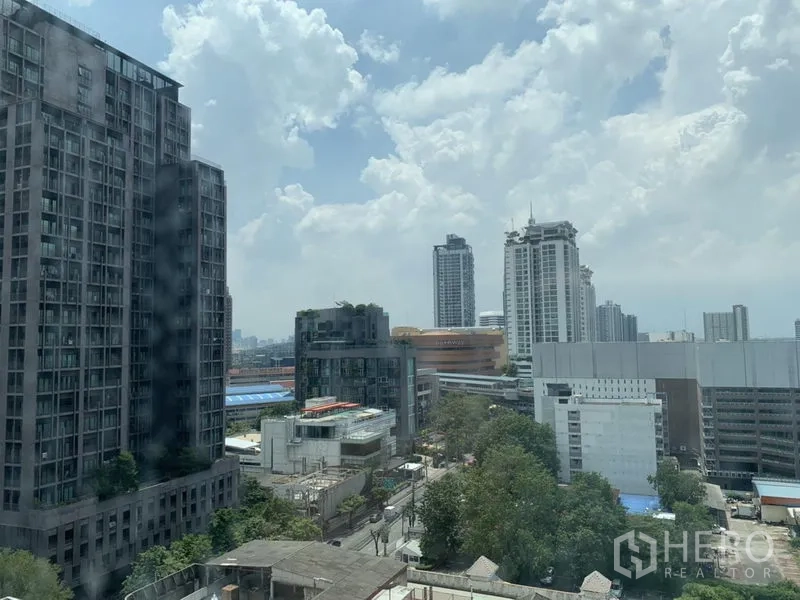 公寓 出租在Watthana, Bangkok - 公寓窗外可见Ekkamai区域城市天际线与晴朗天空。