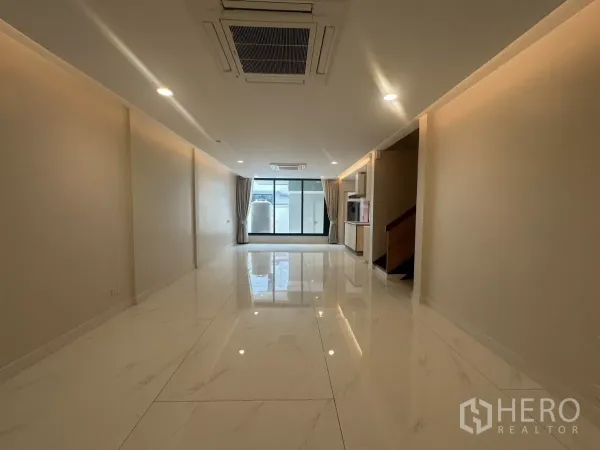联排别墅 出租在Watthana, Bangkok - 开放式客厅，仿大理石亮面地砖与吊顶嵌入式空调。