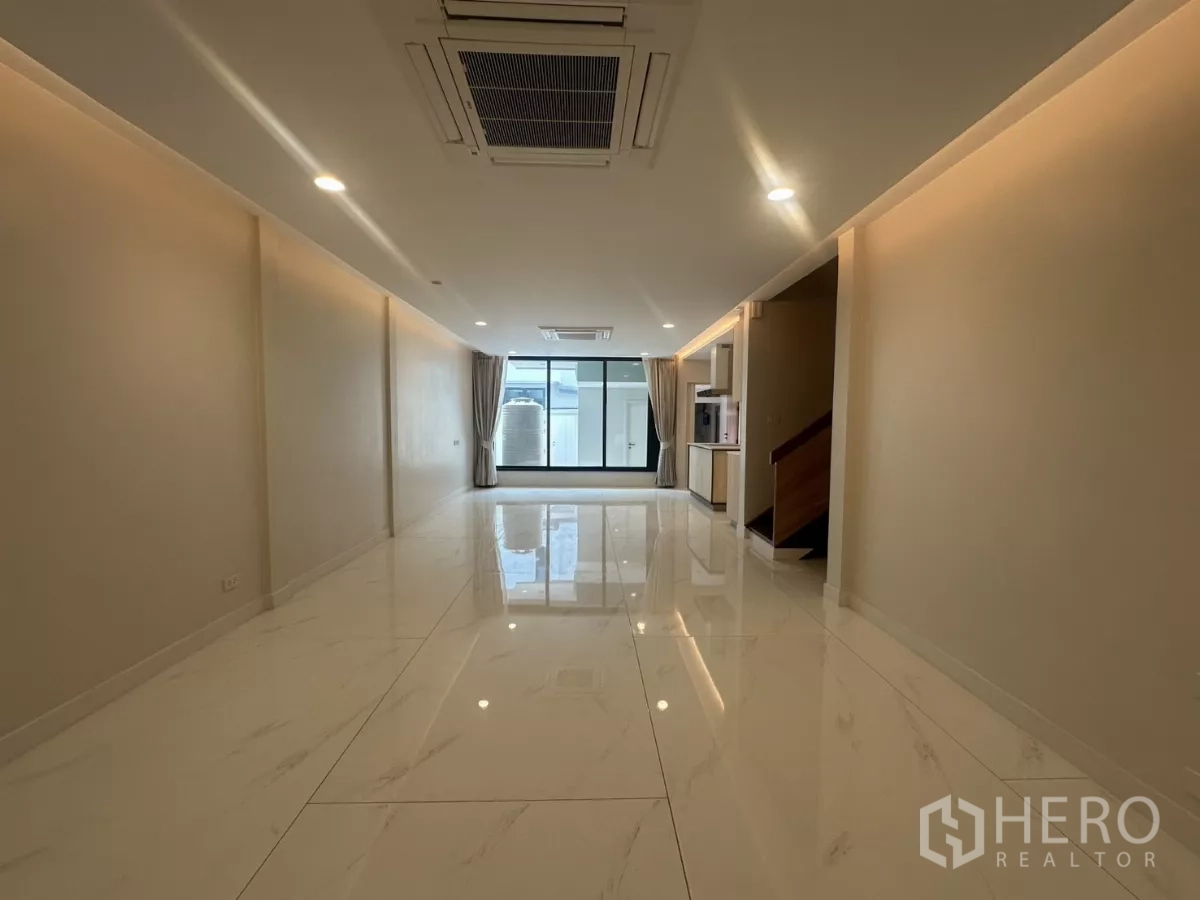 联排别墅 出租在Watthana, Bangkok - 开放式客厅，仿大理石亮面地砖与吊顶嵌入式空调。