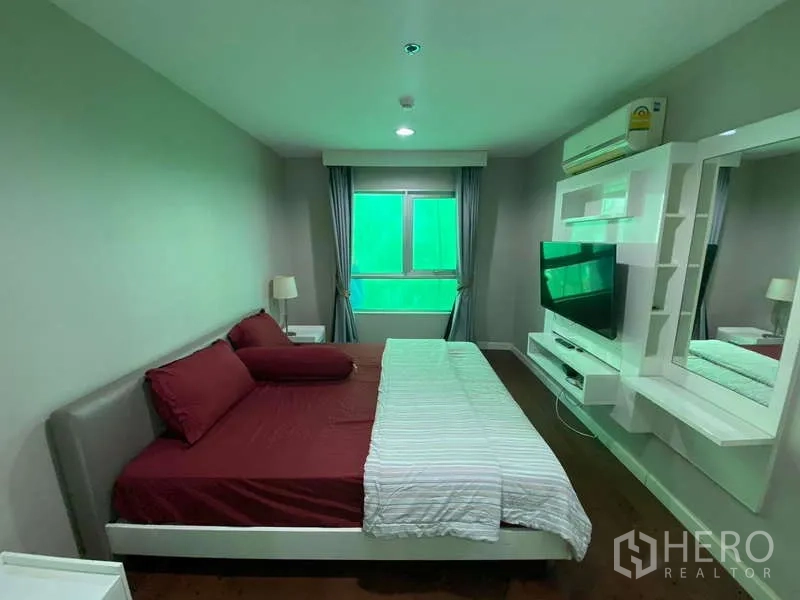 คอนโด for ในHuai Khwang, Bangkok - ห้องนอนใหญ่พร้อมผนังทีวีบิลท์อิน ชั้นวาง โต๊ะข้างเตียง และหน้าต่าง
