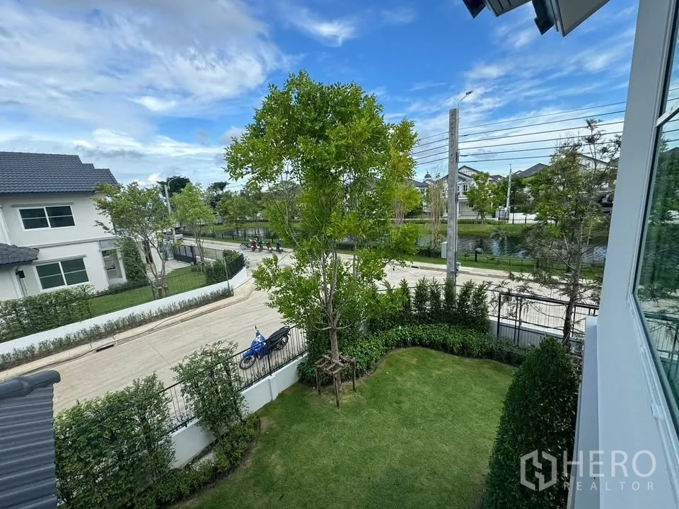 Detached House for rent in Bang Phli, Samut Prakan - View from the upper floor over a green front lawn, quiet street, and a small canal.