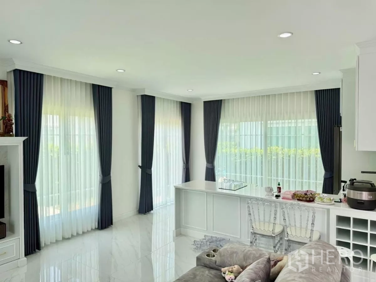 บ้าน ให้เช่าในBang Phli, Samut Prakan - พื้นที่นั่งเล่นแบบเปิดเชื่อมครัว มีเคาน์เตอร์บาร์และเก้าอี้ใส
