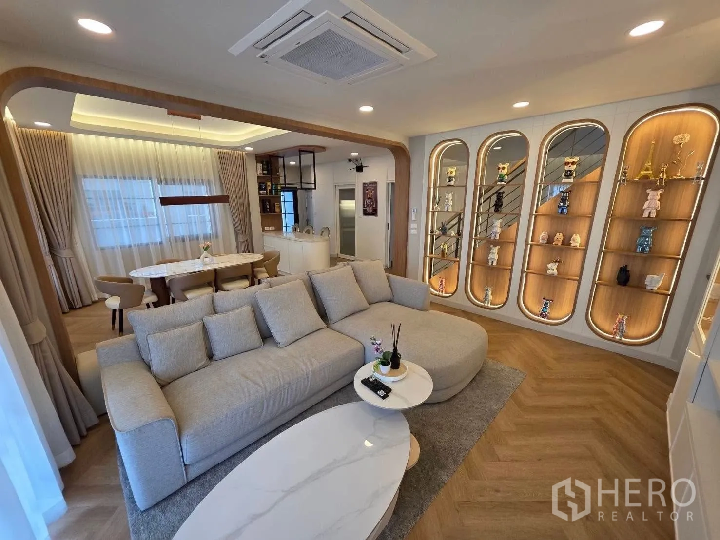 独栋房屋 for rent or sale in Bang Phli, Samut Prakan - 宽大沙发的明亮客厅，墙面为高挑展示架。
