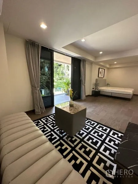 บ้าน ให้เช่าในSuan Luang, Bangkok - พื้นที่นั่งเล่นชั้นล่างเปิดออกสู่เฉลียงสวนผ่านประตูกระจกบานเลื่อน