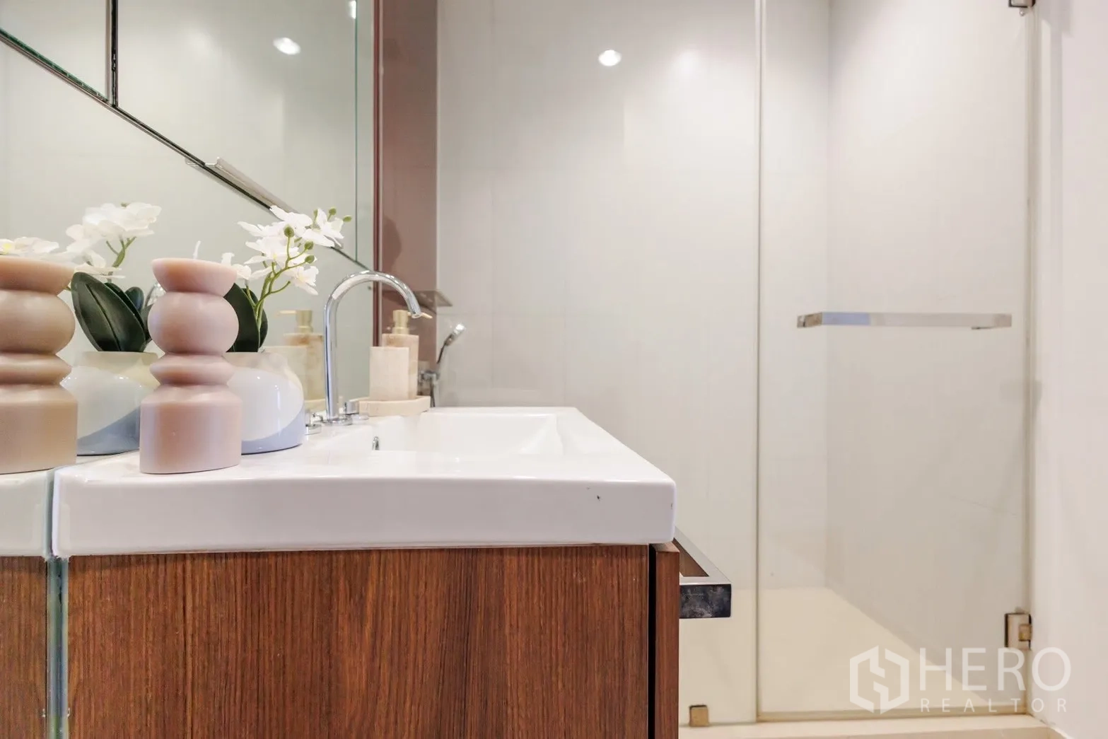 คอนโด for rent or sale in Pathum Wan, Bangkok - ห้องน้ำสไตล์โมเดิร์นพร้อมเคาน์เตอร์ลอยไม้บิวท์อิน กระจกบานใหญ่ และตู้อาบน้ำกระจก