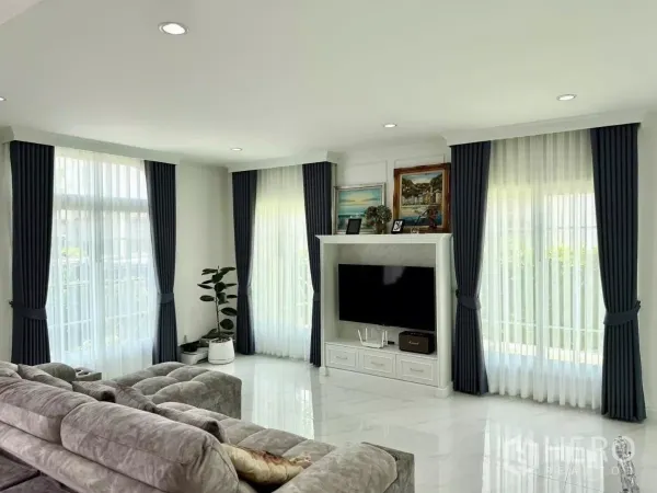 บ้าน ให้เช่าในBang Phli, Samut Prakan - ห้องนั่งเล่นสว่าง ผ้าม่านโปร่ง โซฟาขนาดใหญ่ และตู้ทีวีโทนขาวโมเดิร์น