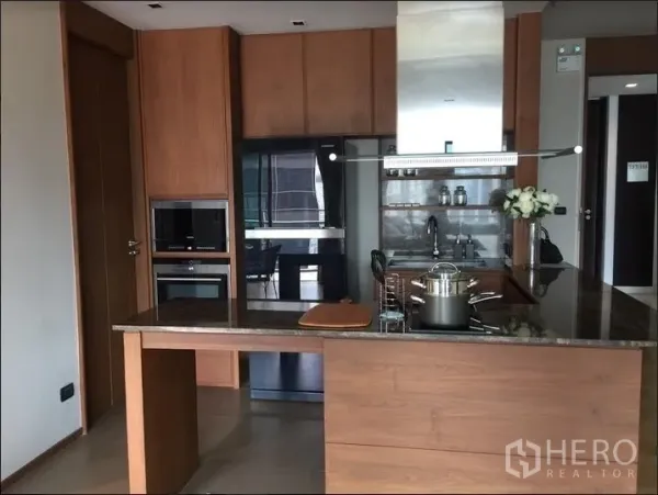 公寓 出租在Watthana, Bangkok - 现代开放式厨房，木质橱柜、石材中岛、嵌入式烤箱与抽油烟机。