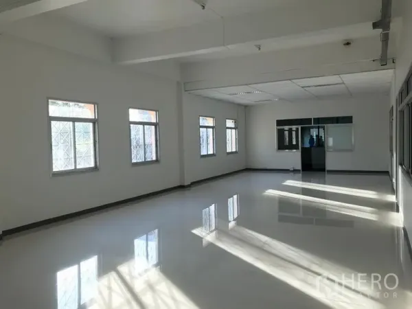 Factory for rent in Mueang Samut Prakan, Samut Prakan - Bright office space with glossy tile floor, multiple windows and clean white walls.