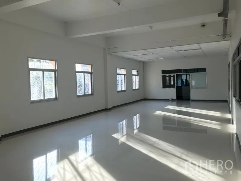 Factory for rent in Mueang Samut Prakan, Samut Prakan - Bright office space with glossy tile floor, multiple windows and clean white walls.