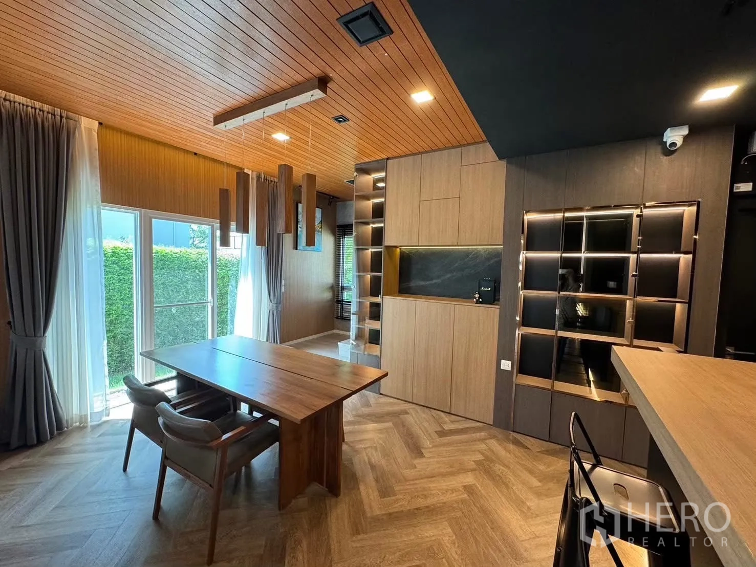 Detached House for rent in Prawet, Bangkok - Open-plan living space with sofa, breakfast bar and media wall.