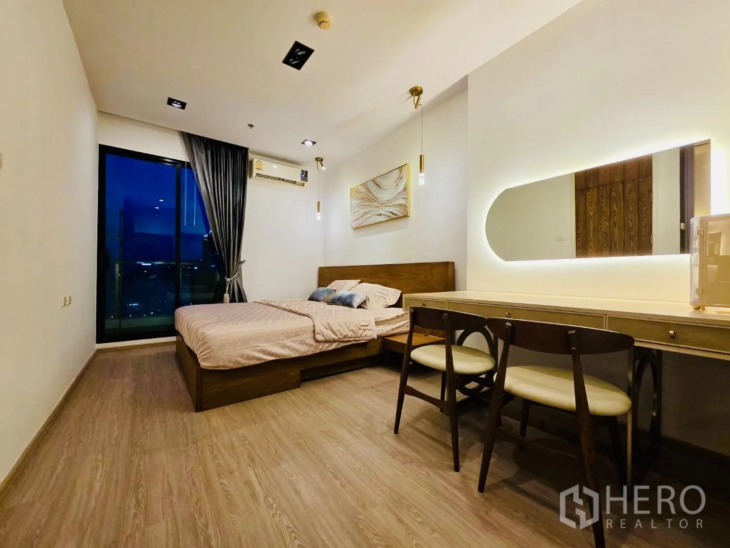 คอนโด for rent in Huai Khwang, Bangkok - ห้องนอนกว้างยามค่ำ เตียงคิงไซส์ โต๊ะเครื่องแป้งยาว และหน้าต่างพร้อมผ้าม่าน