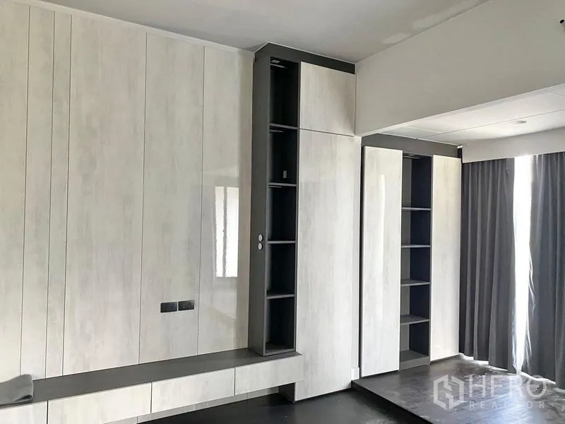 Detached House for sale in Bang Kapi, Bangkok - Bedroom with built-in wardrobes and open shelving, full-height curtains and soft lighting.