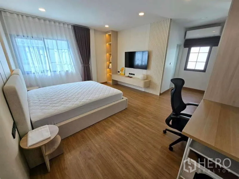 独立式住宅 出租在Bang Phli, Samut Prakan - 通透明亮卧室，带定制柜、电视墙与书桌。