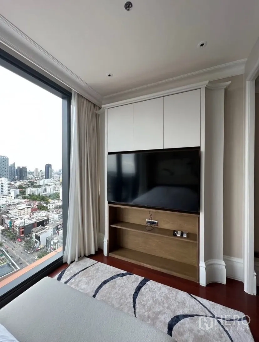 Condominium for rent or sale in Watthana, Bangkok - Corner bedroom with panoramic city view and built-in TV unit.
