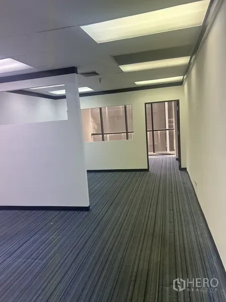 Office Space for rent in Pathum Wan, Bangkok - Partitioned workspace with overhead fluorescent lighting and a large window for natural light.