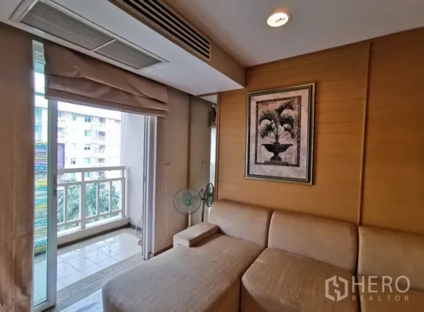 Condominium for sale in Sathon, Bangkok - Cozy lounge corner beside the balcony with wood panel wall, framed artwork and city outlook.