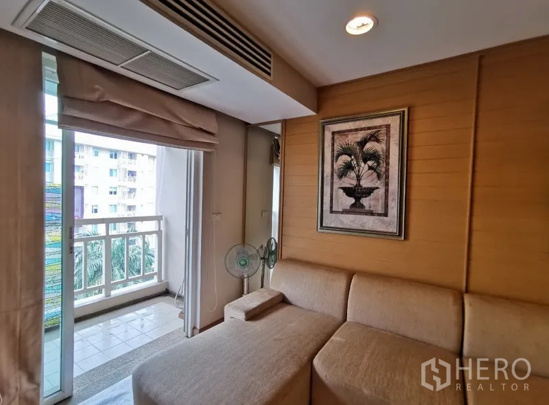 Condominium for sale in Sathon, Bangkok - Cozy lounge corner beside the balcony with wood panel wall, framed artwork and city outlook.