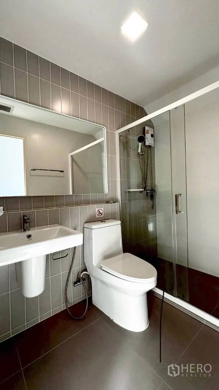 联排别墅 for rent in Prawet, Bangkok - 现代化浴室，带玻璃淋浴房、台盆与大镜子。