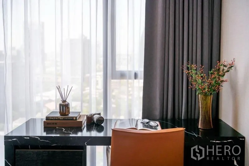 Condominium for rent in Khlong Toei, Bangkok - Work-from-home desk by the window with city view, black marble top and leather chair.