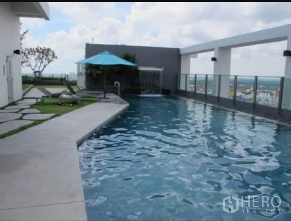 Condominium for rent in Khlong Toei, Bangkok - Rooftop swimming pool with sun loungers, glass railing and skyline views.