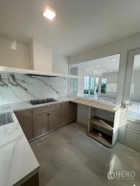 Detached House for rent - Western kitchen featuring a marble-look backsplash, built-in hob, and ample cabinets.