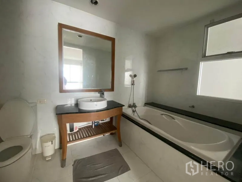 คอนโด ให้เช่าในWatthana, Bangkok - ห้องน้ำพร้อมอ่างอาบน้ำ เคาน์เตอร์อ่างล้างหน้าและกระจก และโถสุขภัณฑ์.