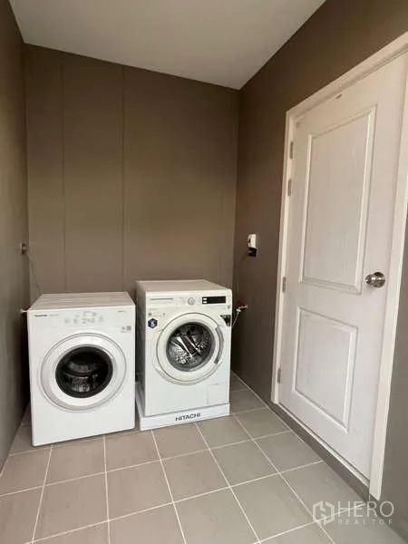 Detached House for rent or sale in Lat Krabang, Bangkok - Laundry room with front-loading washer and dryer on tiled flooring.