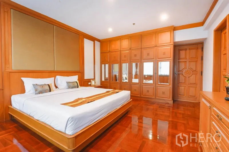 อพาร์ทเมนท์ ให้เช่าในWatthana, Bangkok - ห้องนอนมีตู้เสื้อผ้าบานกระจกเต็มผนัง เตียงคิงส์ และพื้นไม้เงา