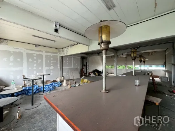 พื้นที่ขายปลีก ให้เช่าในWatthana, Bangkok - ระยะใกล้ของท็อปเคาน์เตอร์พร้อมโคมไฟสไตล์วินเทจและผนังรอซ่อมตกแต่ง