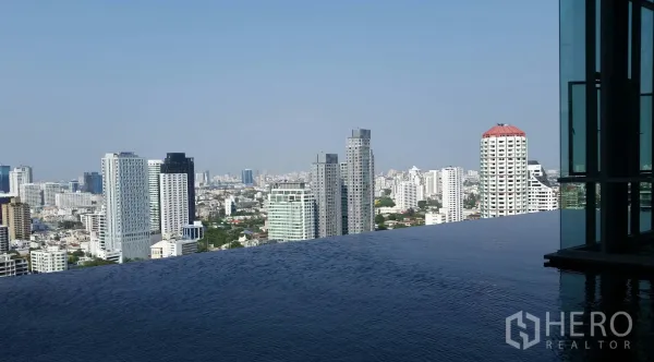 Condominium for rent in Khlong Toei, Bangkok - Rooftop infinity pool with panoramic Bangkok skyline views from a high-rise condominium.